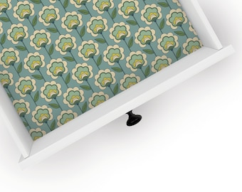 May include: A white drawer with a floral pattern liner. The drawer has a black knob.