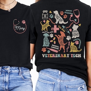 May include: Black t-shirt with a stethoscope and the name "Mary" on the front. The back of the shirt has a colorful design of various veterinary-related icons, including a paw print, a dog, a cat, a syringe, and the text "VETERINARY TECH".
