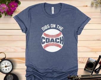 May include: Heather navy blue t-shirt with a white baseball graphic and the text "Dibs on the Coach".