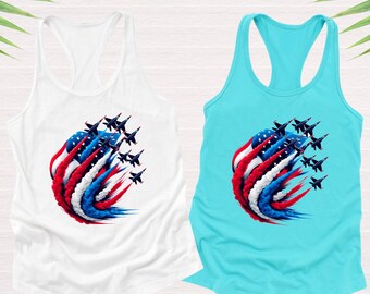 May include: Two tank tops with a graphic of a red, white, and blue American flag with a group of black jets flying in formation leaving a trail of smoke in the colors of the flag. The tank tops are white and turquoise.