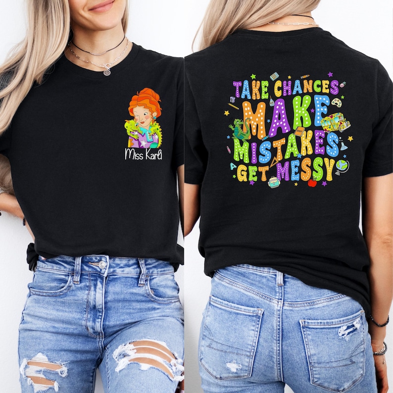 May include: Black t-shirt with a colorful graphic on the back that says "Take Chances Make Mistakes Get Messy". The front of the shirt has a cartoon image of a teacher with the text "Miss Karl" underneath.