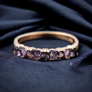 May include: A rose gold band ring with seven triangular amethyst gemstones set in a row.