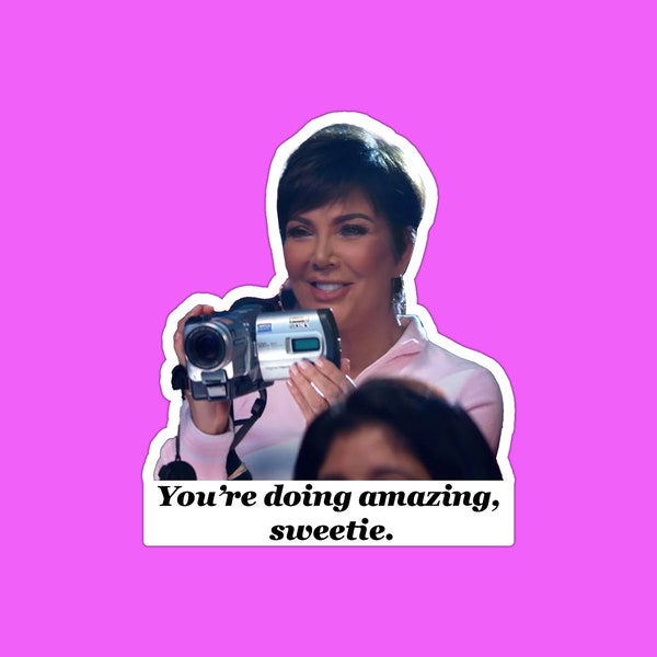 May include: A woman with short brown hair holds a camcorder and smiles at the camera. The text "You're doing amazing, sweetie." is below her.