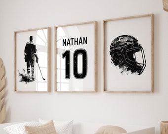 May include: Three framed prints with a hockey theme. One shows a hockey player in action, another displays the name "NATHAN" and the number "10", and the third features a hockey helmet. The prints are in black and white with wooden frames, displayed above a white bed.