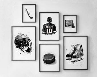 May include: A collection of framed black and white watercolor art prints featuring hockey-themed illustrations. The prints depict a hockey stick, a helmet, a jersey with the name "Denise" and the number "10", a net, a puck, and ice skates.