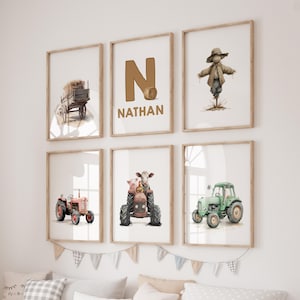 Puede incluir: Seis impresiones enmarcadas con temática de granja. Las imágenes incluyen un carro de heno, la letra "N" con el nombre "Nathan", un espantapájaros, un tractor rojo, una vaca y un cerdo en un tractor y un tractor verde. Los marcos son de color marrón claro.