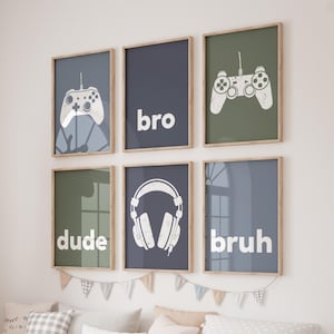 May include: Six framed prints with a gaming theme. The prints feature a white game controller, headphones, and the words "bro", "dude", and "bruh" in white against blue and green backgrounds. The frames are light brown.