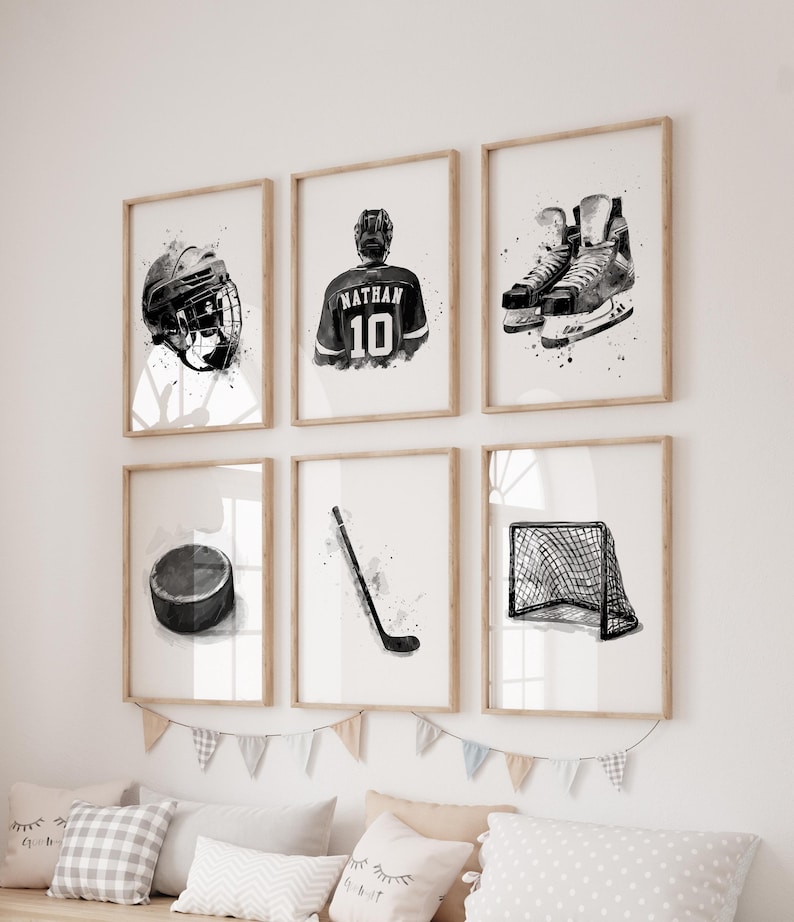 May include: Six framed black and white watercolor prints of hockey equipment and a player. The prints include a helmet, jersey with the name "Nathan" and the number 10, skates, a puck, a hockey stick, and a net.