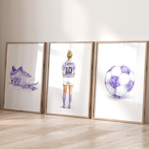May include: Three framed watercolor illustrations of a soccer player, a soccer ball, and a soccer cleat. The player is wearing a purple jersey with the number 10 and the name Sammy on the back. The soccer ball is purple and white. The soccer cleat is purple and white.