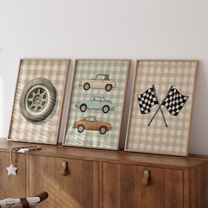 May include: Three framed prints with a vintage car theme. One shows a car wheel, another displays three classic cars, and the third has crossed checkered flags. The prints have a neutral colour palette with a checkered background.