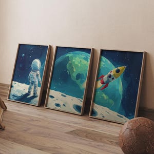 Könnte beinhalten: Drei gerahmte Drucke, die Weltraummotive zeigen. Der erste Druck zeigt einen Astronauten, der auf dem Mond steht, der zweite Druck zeigt eine Ansicht der Erde aus dem Weltraum und der dritte Druck zeigt eine Rakete, die durch den Weltraum fliegt.
