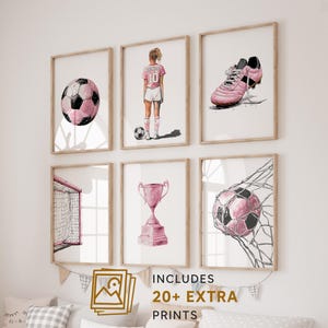 以下が含まれることがあります： サッカーをテーマにした、額装された水彩画プリントの6枚セット。ピンクのサッカーボール、サッカー選手、ピンクのクリート、ゴール、トロフィー、ネットに入ったサッカーボールが描かれています。「INCLUDES 20+ EXTRA PRINTS」の文字も表示されています。