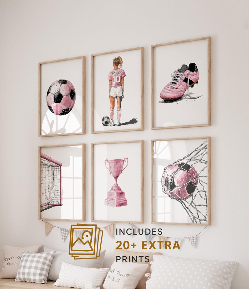 以下が含まれることがあります： サッカーをテーマにした、額装された水彩画プリントの6枚セット。ピンクのサッカーボール、サッカー選手、ピンクのクリート、ゴール、トロフィー、ネットに入ったサッカーボールが描かれています。「INCLUDES 20+ EXTRA PRINTS」の文字も表示されています。