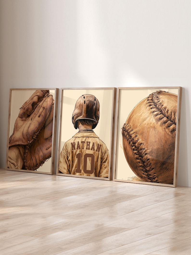 May include: A set of three framed wall art prints featuring baseball themes. The left print shows a leather baseball glove, the center print depicts a baseball player wearing a helmet and jersey with the name NATHAN and number 10, and the right print shows a baseball.