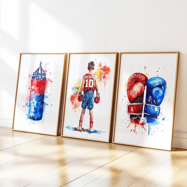 May include: Three watercolor paintings in gold frames depicting boxing imagery. The first painting shows a blue and red boxing bag. The second painting shows a boxer wearing red shorts and a red and white jersey with the number 10 on it. The third painting shows a pair of boxing gloves, one red and one blue.