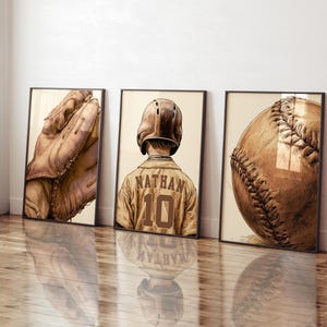 May include: Three framed wall art prints featuring baseball themes in a sepia-toned illustration style. The left print shows a leather baseball glove, the center print depicts a player wearing a helmet and jersey with the name NATHAN and number 10, and the right print displays a close-up of a baseball.