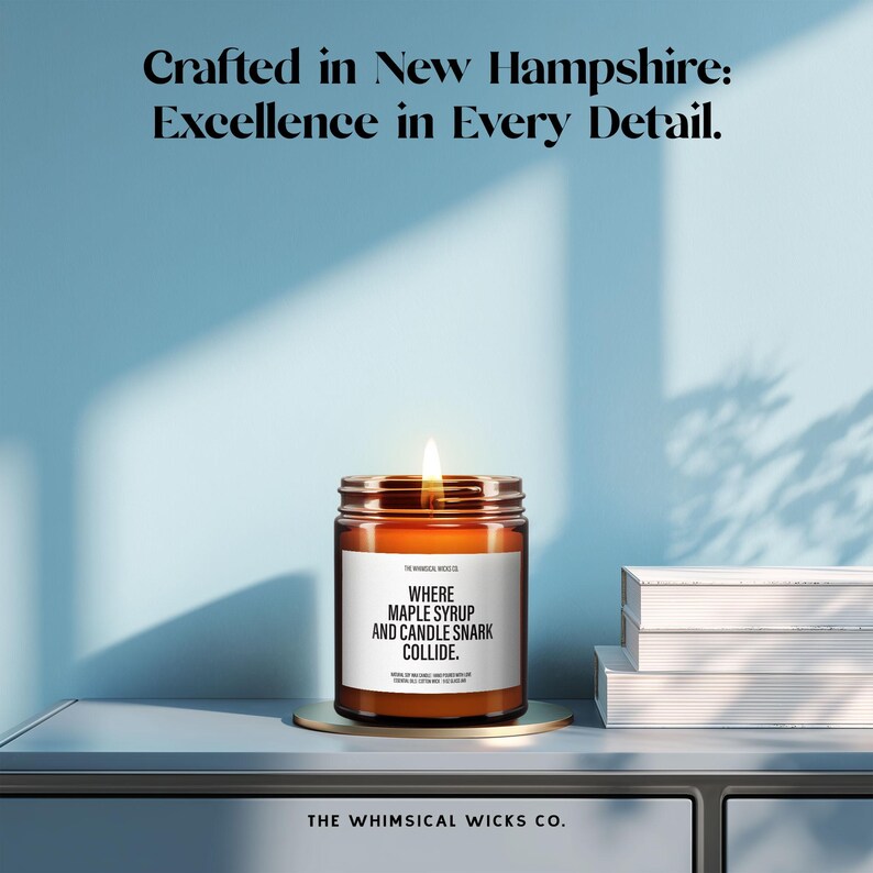 May include: A lit candle in a glass jar with a gold lid, featuring a white label with the text "WHERE MAPLE SYRUP AND CANDLE SNARK COLLIDE." The image also includes the text "Crafted in New Hampshire: Excellence in Every Detail."