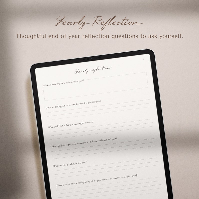 May include: A digital tablet with a white background and black frame displays a printable worksheet with the title "Yearly Reflection." The worksheet includes questions to help reflect on the past year, such as "What sentence or phrase sums up your year?" and "What are you grateful for this year?"