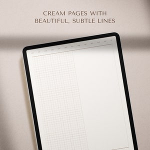 May include: A cream-colored planner with a grid pattern on the left page and a blank page on the right. The planner has a black cover and a brown header with the months of the year printed across the top.