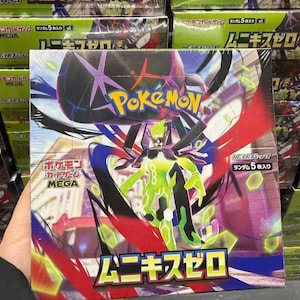 May include: A sealed Pokemon trading card game booster box featuring a central green and black creature illustration. The box displays the Pokemon logo, Japanese text, and a label indicating five cards per pack, set against a vibrant background.