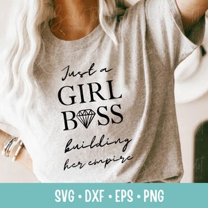 May include: A gray t-shirt with the text "Just a Girl Boss building her empire" in black lettering. A diamond graphic is included in the text.