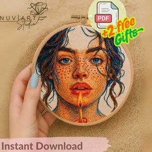 May include: An embroidery hoop featuring a detailed portrait of a person with blue eyes, freckles, and orange hair. The person's lips are open, with a candle flame extending from them. The text "Instant Download" is at the bottom.
