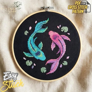 Peut inclure: Motif de point de croix avec deux carpes koï bleues et roses, entourées de nénuphars, sur fond noir. Le motif est présenté dans un cercle à broder en bois. Le texte sur l'image indique "PDF Cross Stitch Pattern" et "Easy Stitch".
