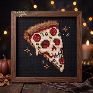 May include: A cross-stitch embroidery in a dark wood frame featuring a slice of pizza shaped like a human skull. The design includes a brown crust, white cheese, red pepperoni slices, and small green herbs on a black fabric background with orange stars.