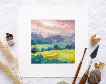 May include: A framed oil painting depicting a landscape with rolling hills and a cloudy sky. The painting is done in shades of green, blue, yellow, and pink.