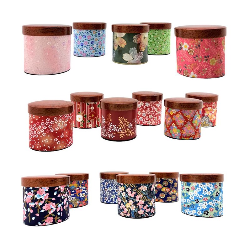 May include: A collection of cylindrical storage canisters featuring dark wood lids and bodies decorated with various colourful floral and geometric patterns. The containers display diverse designs including cherry blossoms, leaves, and intricate motifs.
