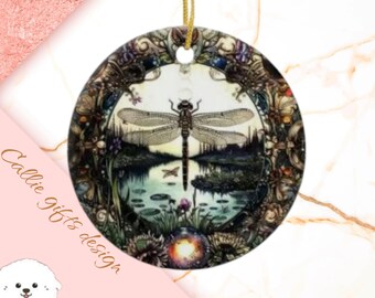 May include: A round, white ceramic ornament with a detailed, intricate design featuring a dragonfly in the center. The dragonfly is surrounded by a floral pattern and a dark blue background. The ornament is perfect for adding a touch of nature to your holiday decor.