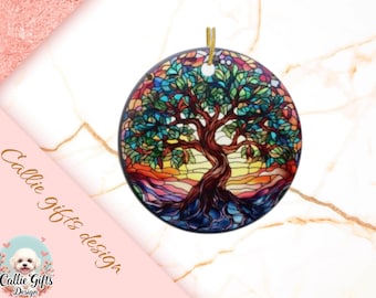 May include: Round ornament featuring a stained-glass tree design with a gold string for hanging. The tree has a brown trunk and branches with green leaves, set against a colorful background of blues, oranges, and yellows. The ornament is a decorative item.