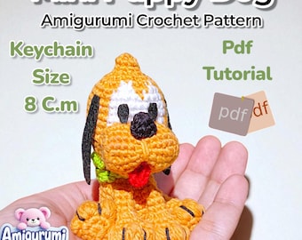 Könnte beinhalten: Ein gehäkelter Mini-Welpen-Amigurumi-Schlüsselanhänger. Der Welpe ist orange, weiß, schwarz und rot, mit einem grünen Kragen. Der Text auf dem Bild lautet "Mini Puppy Dog Amigurumi Crochet Pattern" und "Keychain Size 8 cm".