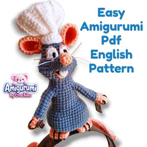 Op de afbeelding: Een gehaakte blauwe rat amigurumi met een witte koksmuts, roze binnenoren, een roze neus en witte tanden. De tekst "Easy Amigurumi Pdf English Pattern" is zichtbaar, samen met een logo met de tekst "Amigurumi By Crochiko".