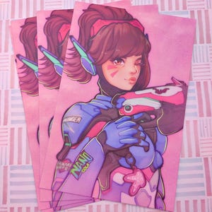 Könnte beinhalten: Ein rechteckiger Kunstdruck mit einer stilisierten Illustration einer Figur mit braunem Pferdeschwanz, die einen blau-rosa mechanischen Anzug mit Headset trägt. Die Figur hält einen rosa-weißen Blaster, mit dem Schriftzug NANO COLA.