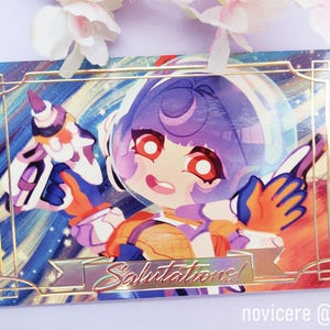 Op de afbeelding: Een kleurrijke illustratie van een personage dat een ruimtepak draagt en een gereedschap vasthoudt. Het personage heeft paars haar en rode ogen. De achtergrond is een galaxie met sterren en een gouden frame. De tekst "Salutations!" is in goud op een banner geschreven.