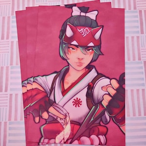 Könnte beinhalten: Ein rechteckiger Kunstdruck mit einer stilisierten Illustration einer Figur mit dunklem Haar, das mit einer weißen Schleife gebunden ist, einer roten Fuchsmaske auf der Stirn, einem weißen Kimono mit rotem Blumenemblem und roten fingerlosen Handschuhen.