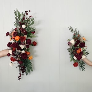 Arrangiamenti per arco nuziale con fiori finti color arancio ruggine bordeaux e terracotta, composizioni floreali per pergolato color arancio ruggine e bordeaux, arco