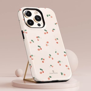 Op de afbeelding: Een witte telefoonhoes met een kersenpatroon en de tekst "MosaicShelter" onderaan.