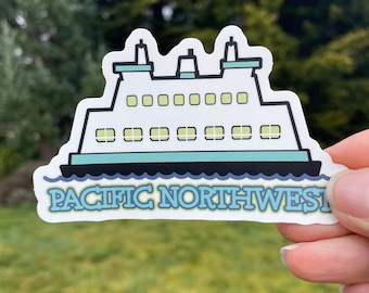 May include: A white ferry boat sticker with blue and green accents. The sticker says "PACIFIC NORTHWEST" in a green and blue font.