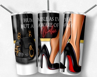 May include: Three stainless steel tumblers with black and gold designs. One tumbler features a black purse with gold accents and a sandal. The other two tumblers have illustrations of high heels and the text "HUMBLE AS EVER BUT AWARE OF MY Value."