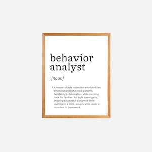 Peut inclure: Une impression encadrée avec un fond blanc et du texte noir qui définit "analyste du comportement" comme un maître de la collecte de données qui identifie les schémas émotionnels et comportementaux, facilite la collaboration, répare l'espoir pour les familles et permet des résultats réussis tout en pivotant sur un sou, généralement sous une montagne de paperasse.