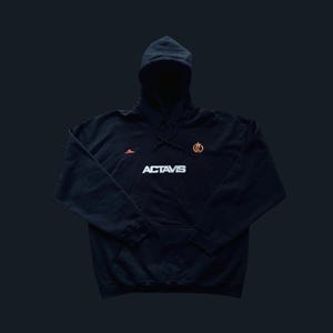 May include: Black hooded sweatshirt with a white logo that says "ACTAVIS" and a small orange logo on the right side of the chest.