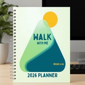 Może przedstawiać: Spiralnie oprawiony planer na rok 2026 z jasnozieloną okładką. Okładka zawiera turkusowo-zieloną grafikę ze słowami "WALK WITH ME" i "MOSES 6:34". Żółte koło znajduje się nad grafiką. Słowa "2026 PLANNER" znajdują się na dole.