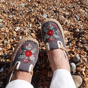 Close up of floral embroidered shoes with detailed stitching on canvas upper, showcasing boho style craftsmanship