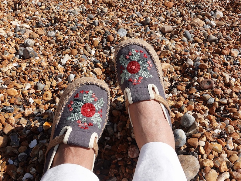 Close up of floral embroidered shoes with detailed stitching on canvas upper, showcasing boho style craftsmanship