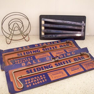May include: An assortment of vintage storage solutions, including two "Ball Bearing Sliding Shelf Bar" packages with blue and orange packaging. Also, a metal wire dish rack and a black metal shelf.