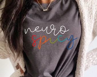 May include: A dark grey heather t-shirt with the text "neuro spicy" written in white with a rainbow colored outline.