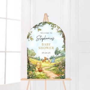 May include: Welcome to Stephanie's Baby Shower sign with a Winnie the Pooh theme. The sign features a whimsical illustration of Winnie the Pooh, Piglet, Tigger, and Eeyore in a forest setting. The date of the shower is 05.24.25.