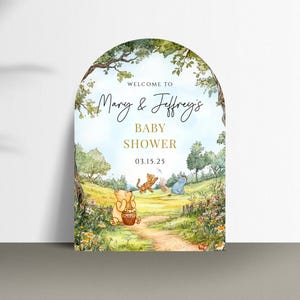 May include: A Winnie the Pooh themed baby shower invitation with a whimsical illustration of Winnie the Pooh, Piglet, and Eeyore in a forest setting. The text reads "Welcome to Mary & Jeffrey's Baby Shower 03.15.25".